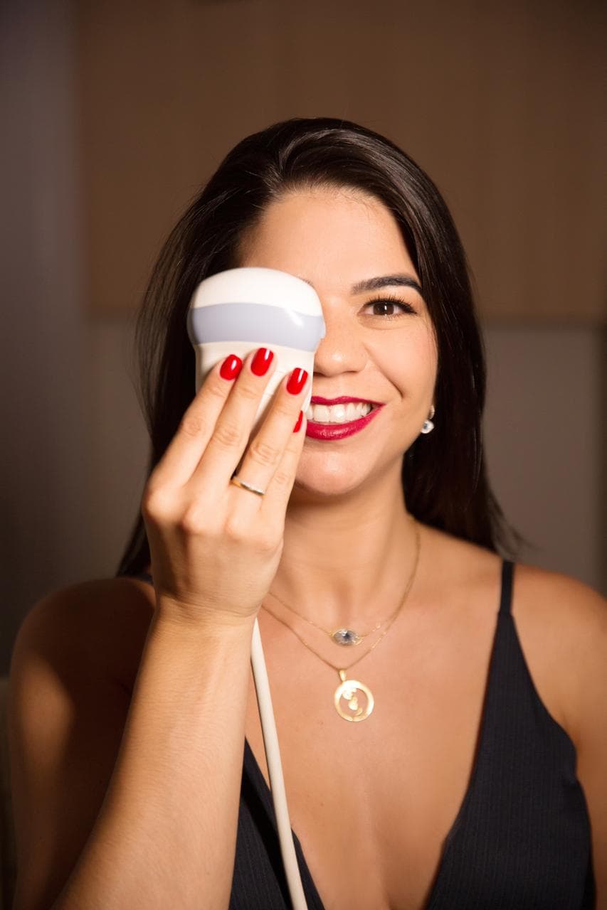 Dra. Camila Insuela com o transdutor de ultrassom